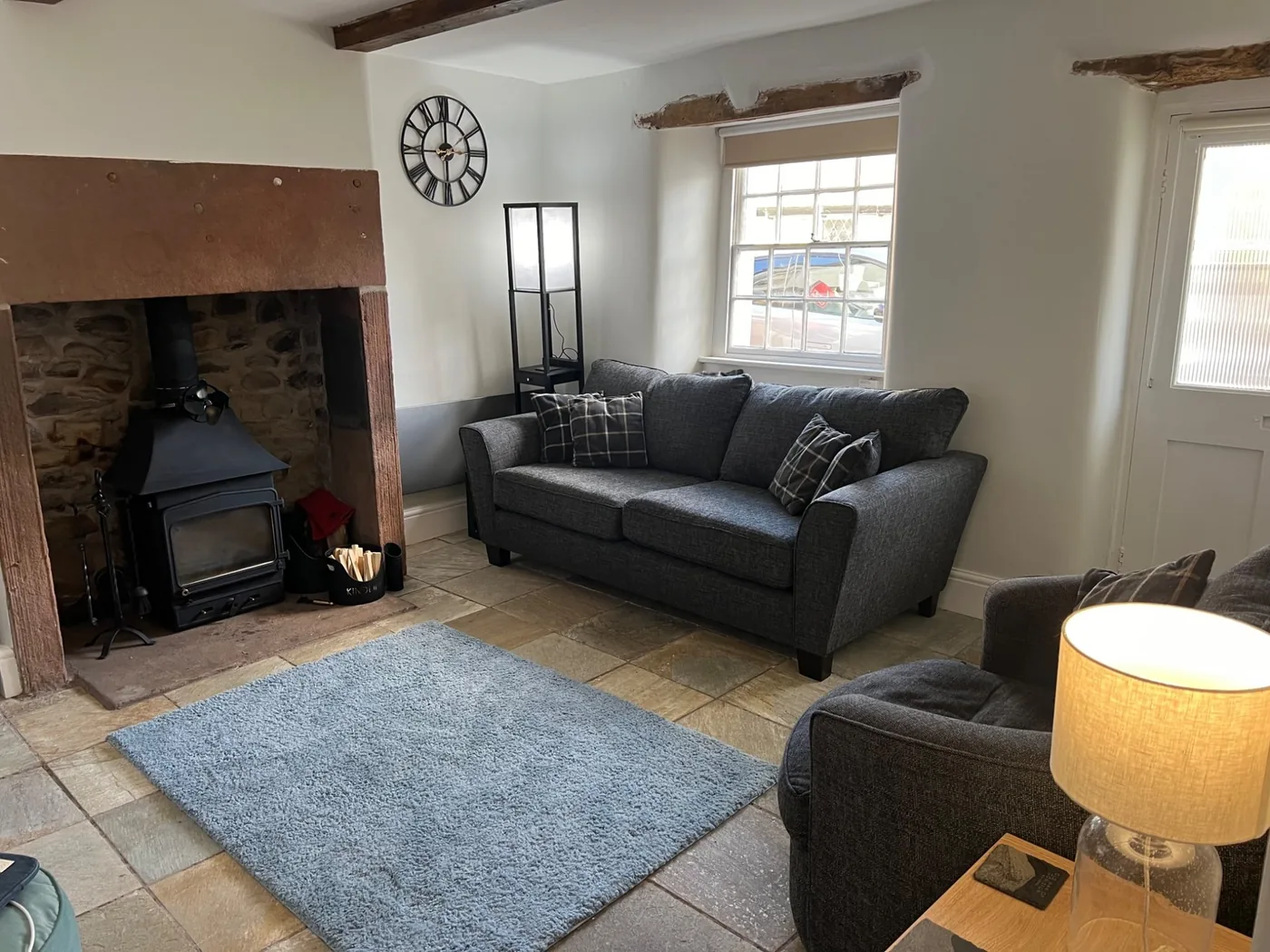 Living room with exposed beams and wood-burning stove